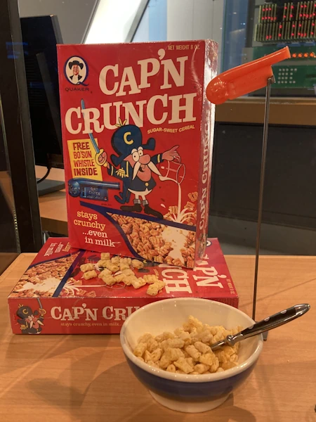 Eine Packung Cap’n Crunch, Frühstücksflocken und eine orange Pfeife.
